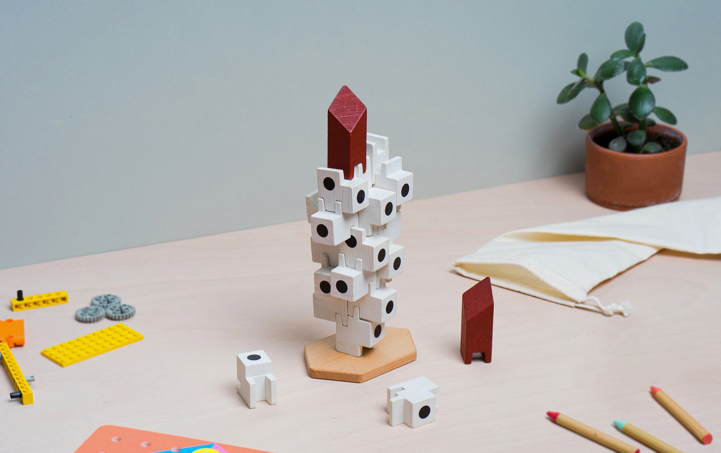 The Japanese Capsule Tower wooden block tower game on a table with a plant in the background