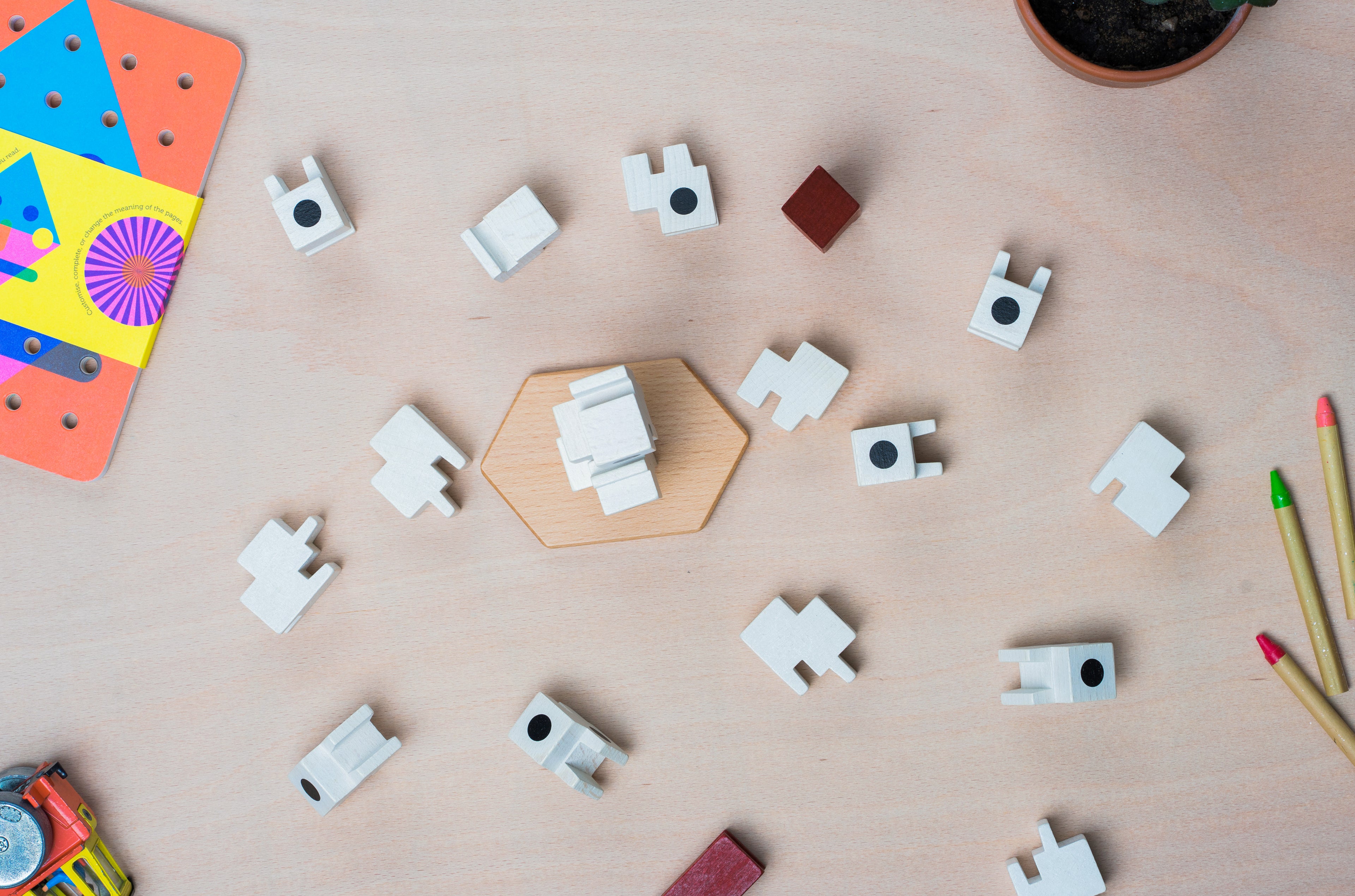Top view of a few building block capsules and  other colourful toys lay on a wooden surface.